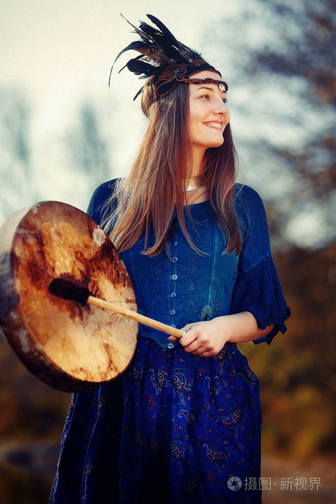 美丽的萨满教女孩在大自然中的萨满框架鼓.