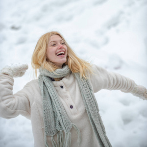 冬天快乐。快乐的小女孩打雪仗。冬天快乐女人的画像。可爱俏皮的年轻女子在户外享受初雪。