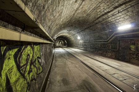 Empty subway tunnel with grafitti by night