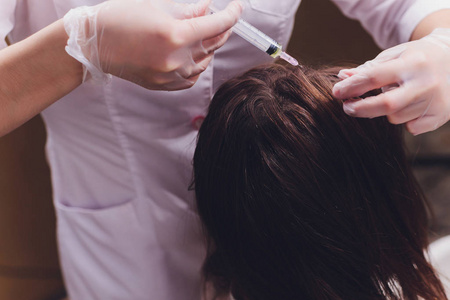 针介疗法。女性头部注射了化妆品。促进头发生长。