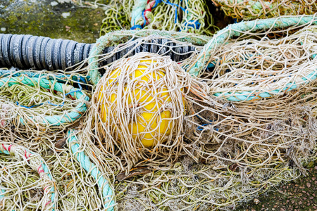 blue fishing net on a pontoon with its ropes and floats covered 