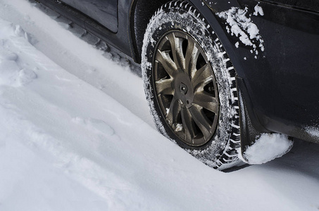 The car in the snow, a wheel closeup in the snow rut. For weathe