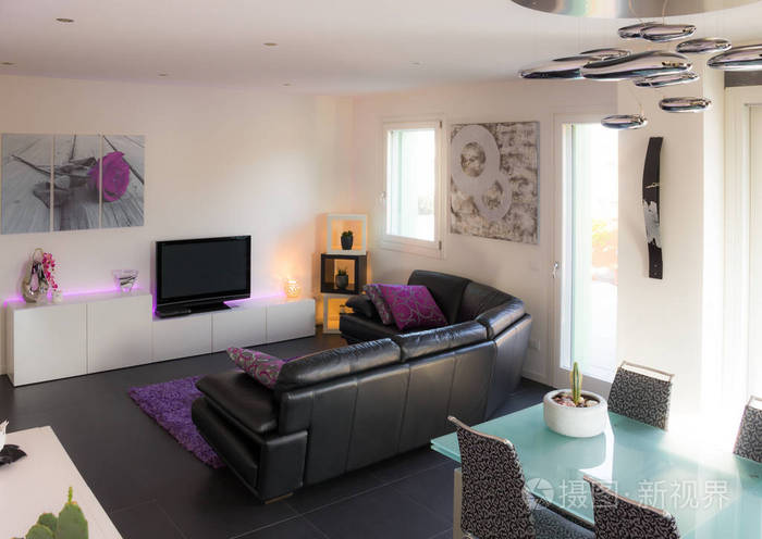 客厅配有现代家具，包括沙发水晶桌抛光的白色装饰墙和黑色地板