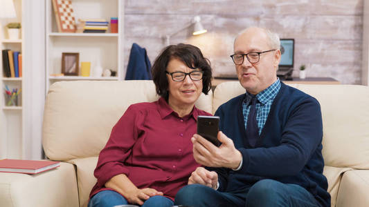 一对老人和一个女人正在用他们的智能手机进行视频通话