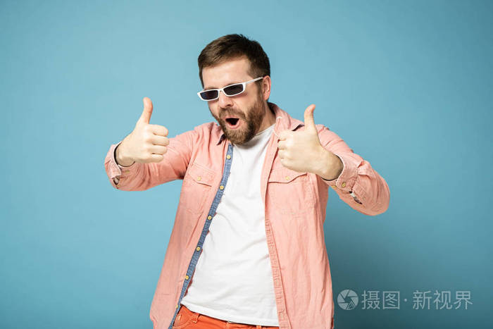 戴着墨镜留着胡须的奇怪男人双手竖起大拇指张开嘴脸上露出奇怪的表情