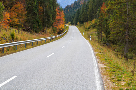 Winding forest road in beautiful autumn colors in Bavaria Alps, 