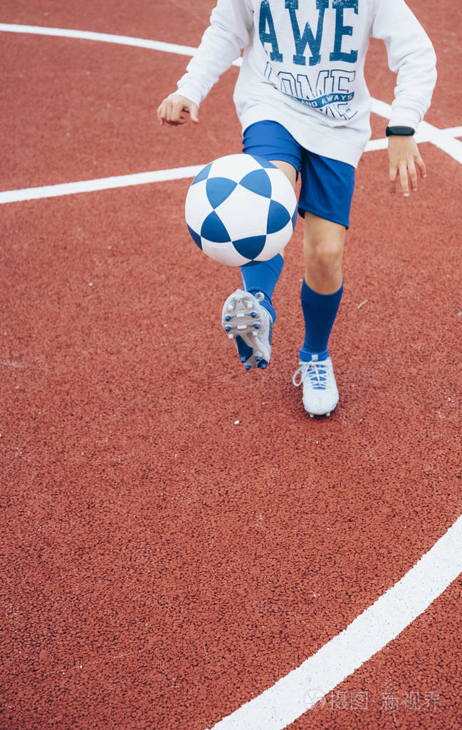 不认识的小男孩在踢足球照片-正版商用图片26t9oa-摄图新视界