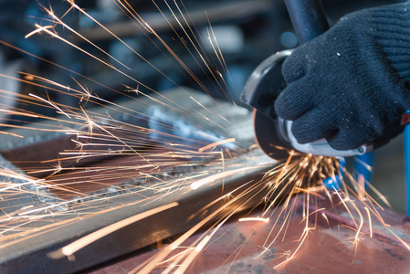 Cut metal with a Angular grinding machine. Sparks are flying. Co