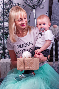 Young mother with little son near decorative Christmas trees on 