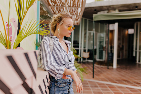 Photo of beautiful stylish woman posing on street on background 