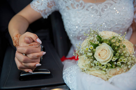 新娘和新郎手拿结婚戒指和婚纱。新娘和新郎的手上戴着结婚戒指。手牵手的新婚夫妇。