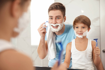 爸爸刮胡子，儿子在浴室模仿他