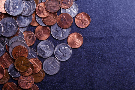 黑桌上放着美国硬币和美元。各种美国硬币