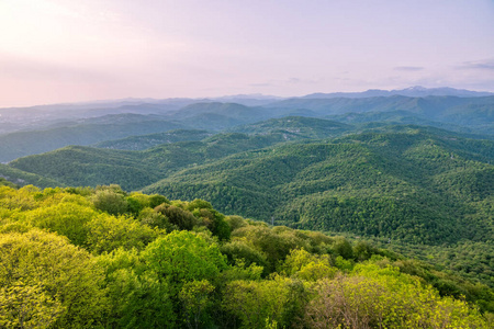 山上美丽的日落.美丽的日落在丘陵山谷,低地有村庄和雾.照片