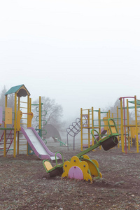 Empty childrens playground on a foggy autumn morning