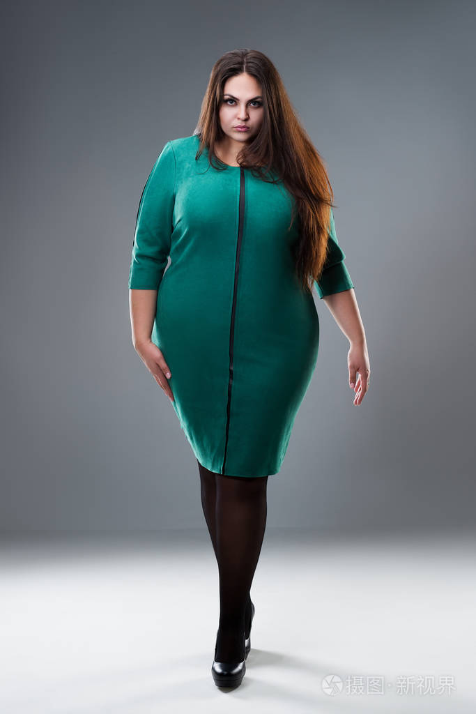 穿绿色连衣裙的大码模特灰色背景下长发的胖女人身材积极