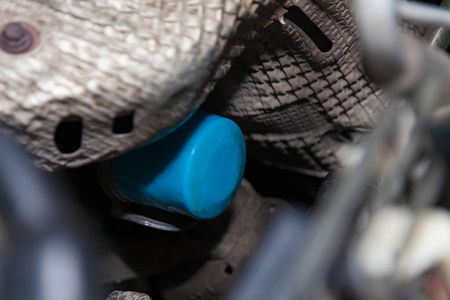 Blue oil filter for a car engine in the engine compartment of a 
