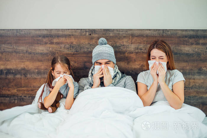 生病的一家人一起躺在床上