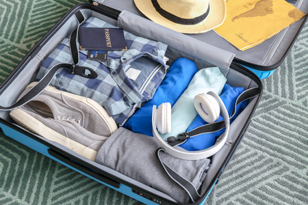 国外房间在家里的地板上放着装满衣服和配件的打开行李箱照片