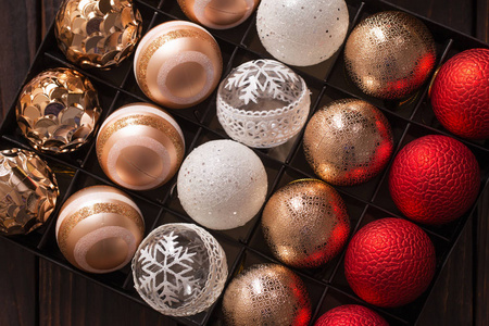 Christmas balls in box on dark wooden background 