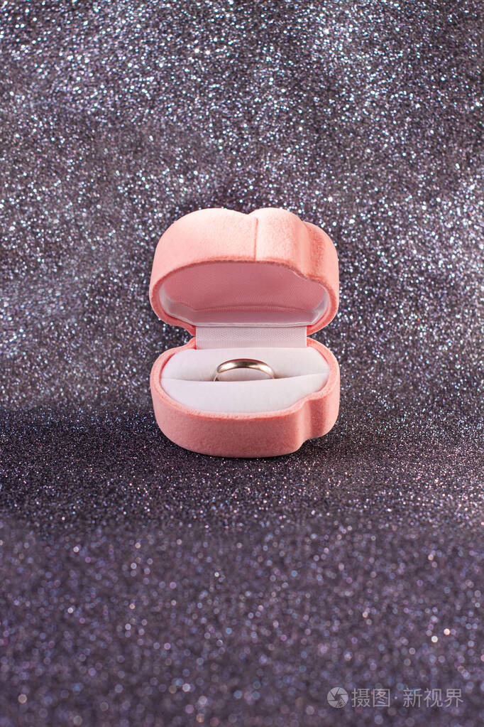 粉红色天鹅绒心形盒子婚礼白金戒指背景为闪亮的黑色闪光正面视图订婚