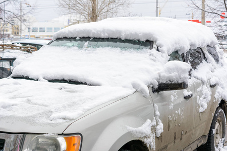 汽车上覆盖着新的白雪,汽车被雪覆盖了一个障碍照片
