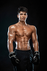 健身和拳击概念。拳击手，在黑色背景上打架或戴手套摆姿势的人。个人体育娱乐。