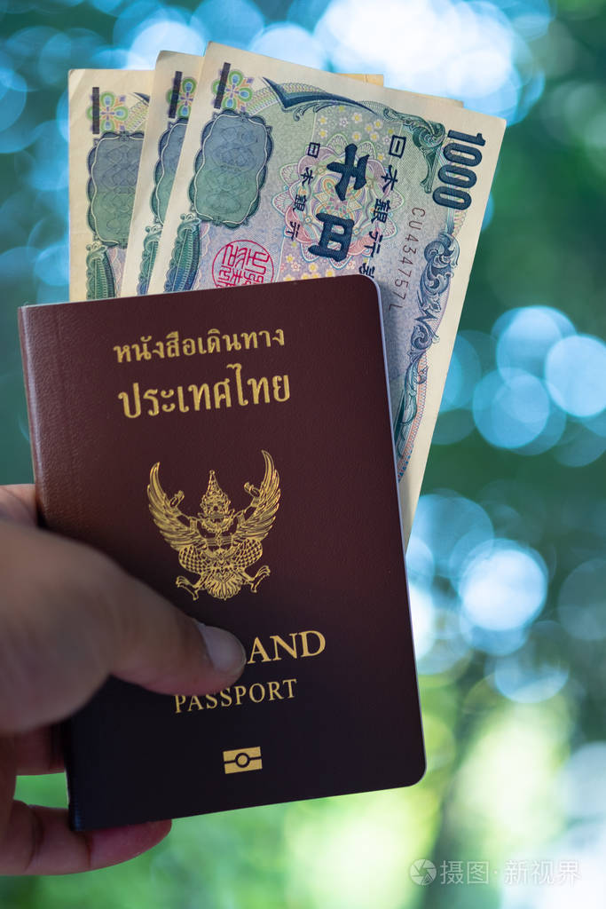 拿着泰国护照的年轻人手里拿着日元