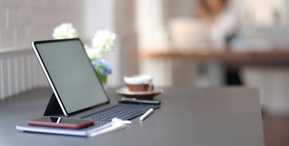 Closeup view of dark stylish workplace with blank screen digita