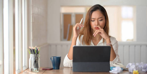 Young beautiful businesswoman concentrated in her work while usi