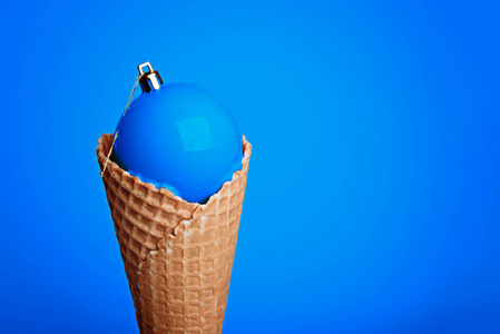 冰淇淋华夫饼蛋卷,蓝色背景上有圣诞球.照片