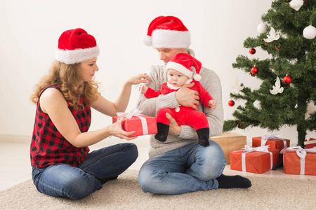 节日，孩子和家庭的概念幸福的夫妇和宝宝一起在家庆祝圣诞节。
