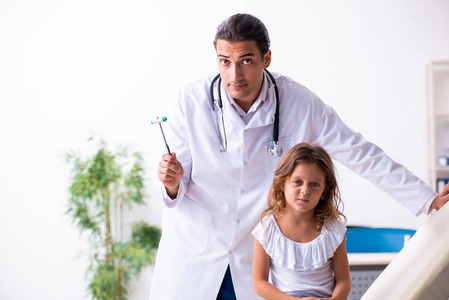 年轻儿科医生带着小女孩
