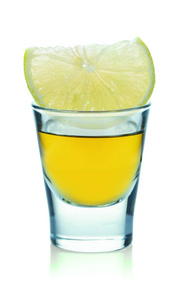 glass with strong alcoholic drink and lemon 