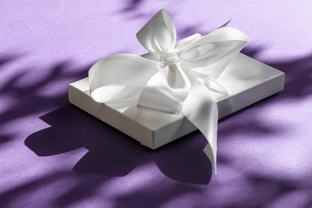 豪华假日白色礼盒，丝带和紫罗兰蝴蝶结