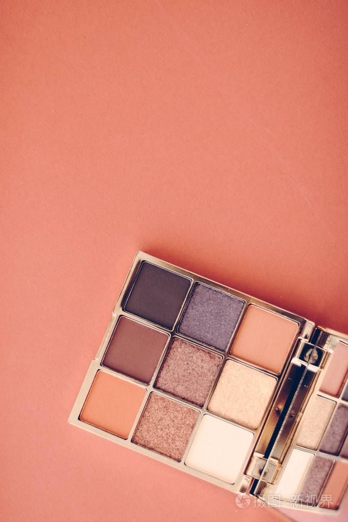 眼影调色板和化妆刷在橙色背景上眼睛