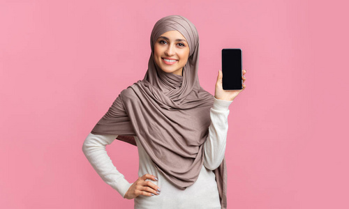 戴头巾的穆斯林女孩展示现代黑屏智能手机