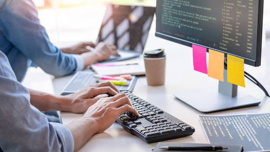 Young startup Programmers Sitting At Desks Working On Computers 