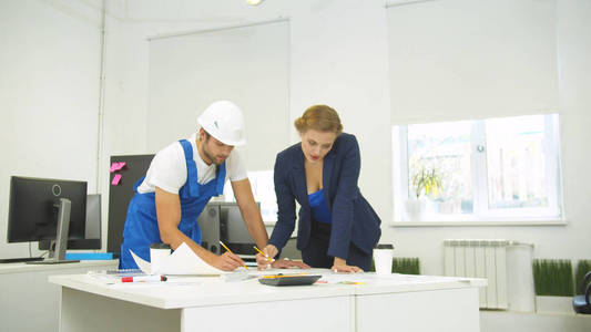 Engineer and builder draw on whatman paper with pencil and ruler