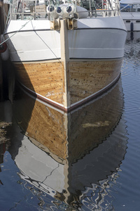 传统渔船在港湾船头的倒影图片