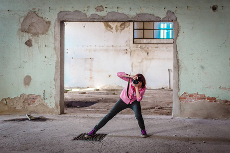 女孩站在摄影师的姿势拍照，空荡荡的厂房。