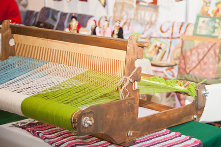 织布机通过编织纱线或线来制造织物的装置。