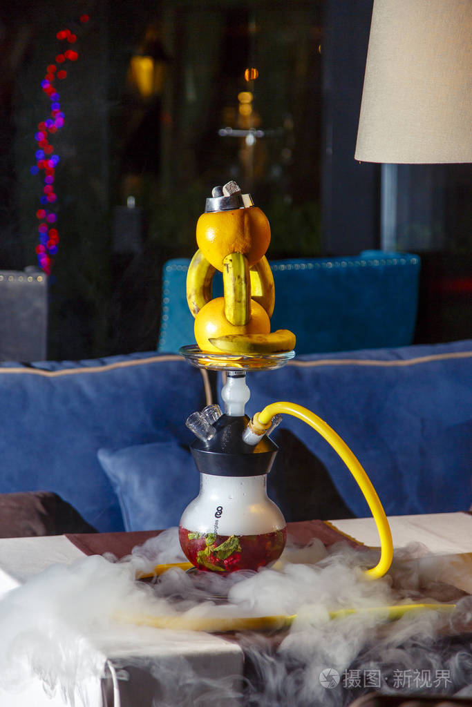 橘子上的水烟橙色水烟水烟壶有一个圆形的透明烧瓶里面漂浮着切成薄片