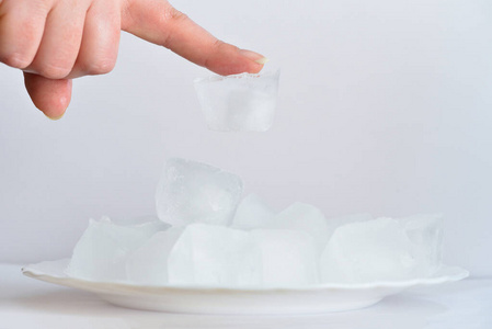 冰冷的手冰冷的冰粘在女孩手上的手指上.冰粘在手指的皮肤上照片