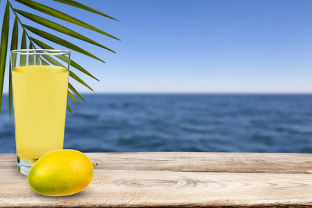 芒果和芒果汁站在靠海的桌子上。