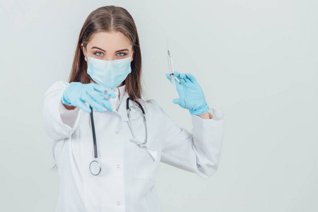 戴着医用面具的女医生拿着注射器，指着其中一个镜头。