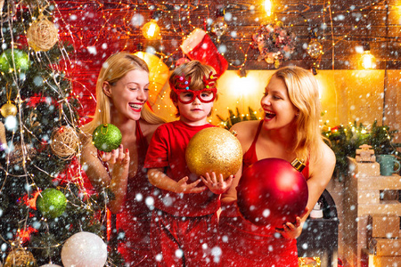 女人红裙子庆祝圣诞节与可爱的小宝宝.家庭纽带.爱和平快乐.