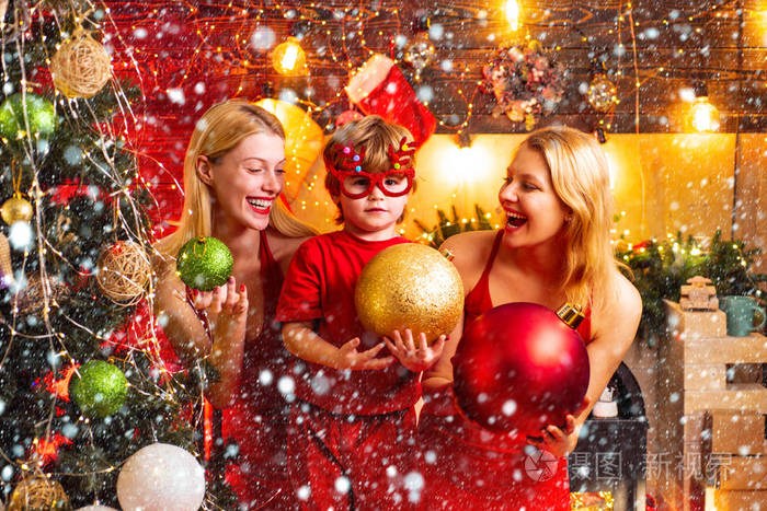 女人红裙子庆祝圣诞节与可爱的小宝宝.家庭纽带.爱和平快乐.