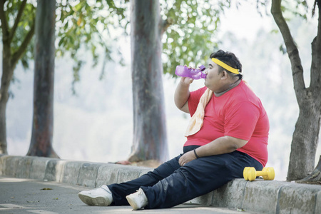胖子跑步亚洲胖子喝瓶装水照片