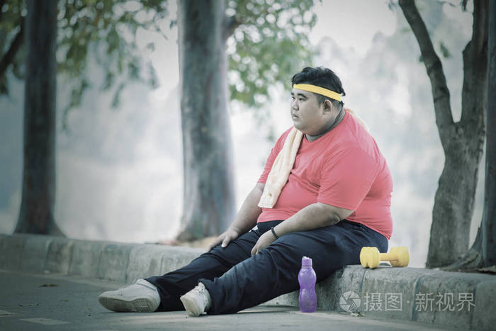胖亚洲男人在路上放松双腿